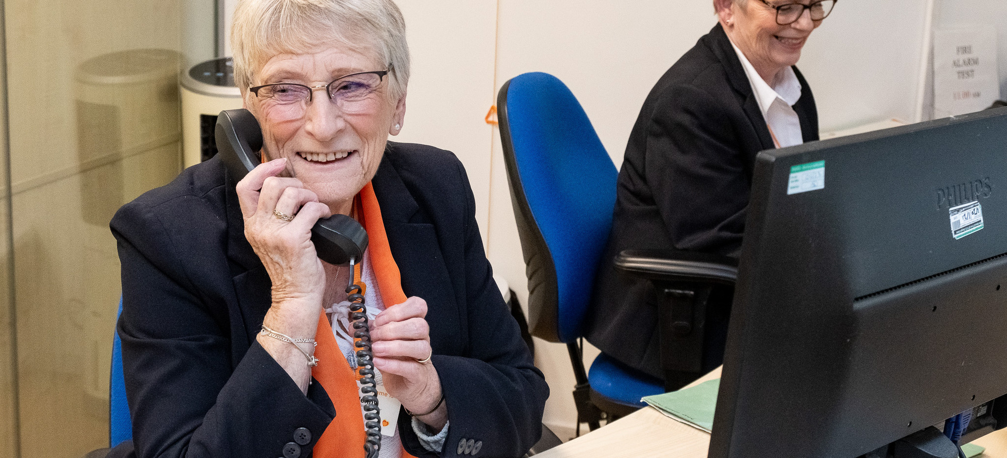 Volunteer receptionist Jenny answers the phone (cropped)