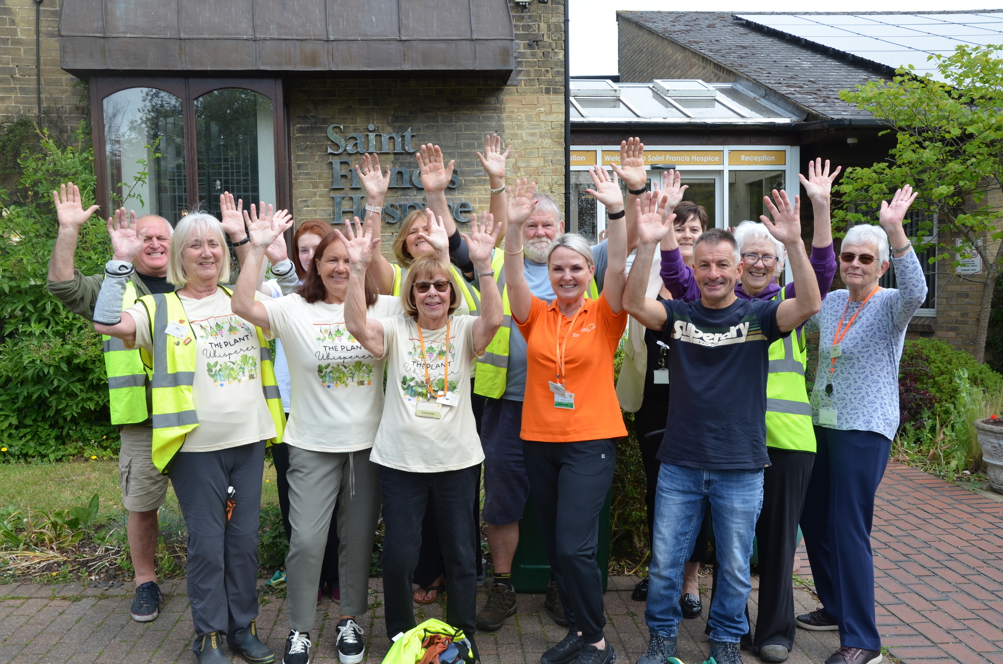 group photo of volunteers with hands in the air